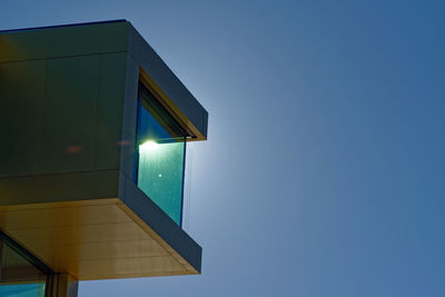 Low angle view of illuminated building against clear blue sky