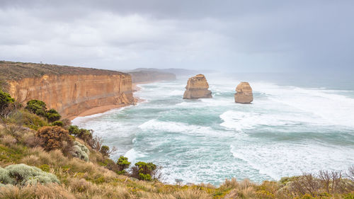 Scenic view of rocks in sea against sky