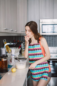 Mid adult woman holding ice cream at home