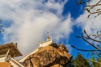 Low angle view of trees and rocks against sky