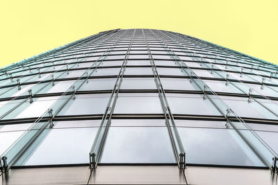 Low angle view of glass building against clear sky