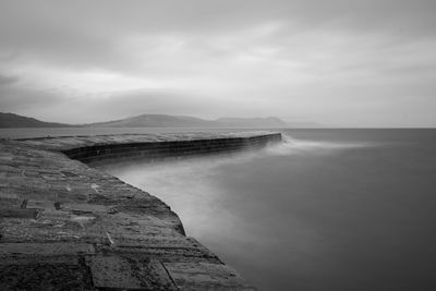 Long exposure of lyme regis pier in dorset in black and white