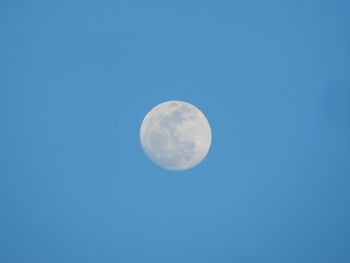 Low angle view of moon against blue sky