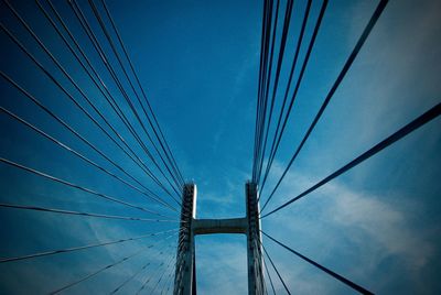 Low angle view of suspension bridge against blue sky