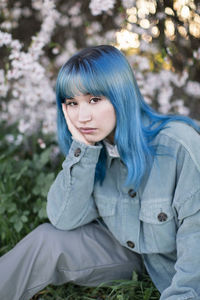 Portrait of beautiful young woman against trees