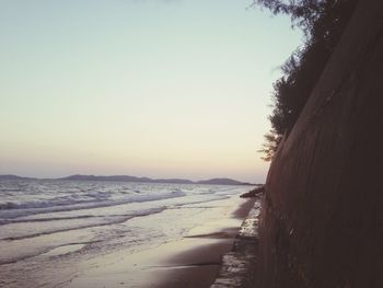 Scenic view of beach against clear sky during sunset