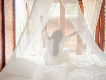 Woman lying on bed at home