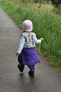 Rear view of woman walking on footpath