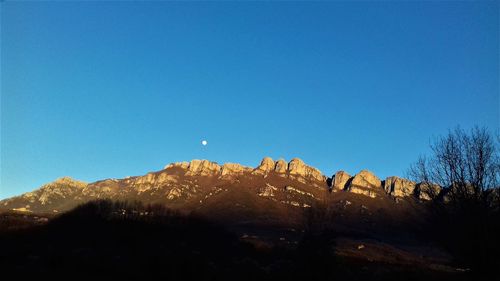 Panoramic view of mountains against clear blue sky
