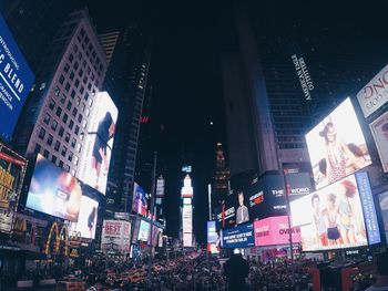 Low angle view of city lit up at night