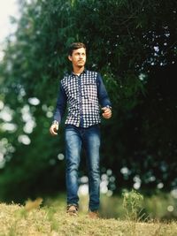 Portrait of young man standing on field