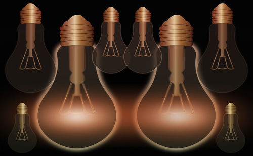 Close-up of illuminated lighting equipment against black background