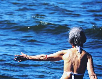 Rear view of shirtless man in sea