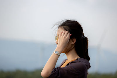 Young woman looking away against wall