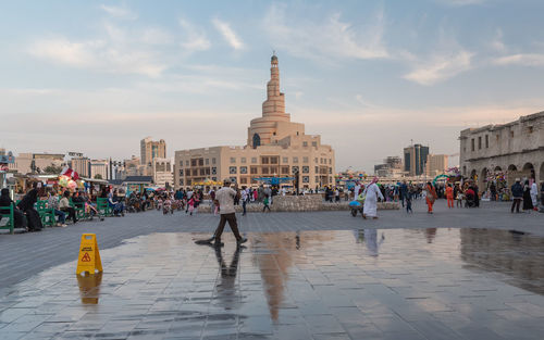 People on street against buildings in city