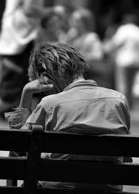 Rear view of man sitting on bench