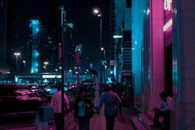 People in illuminated city at night