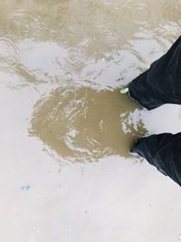Low section of man standing in water
