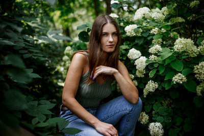 Portrait of young woman sitting on field