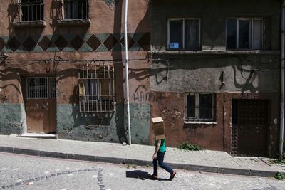 Full length of man walking against building in city