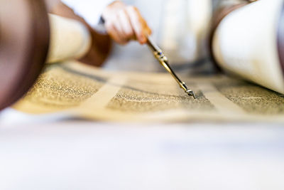 Midsection of person reading holy book