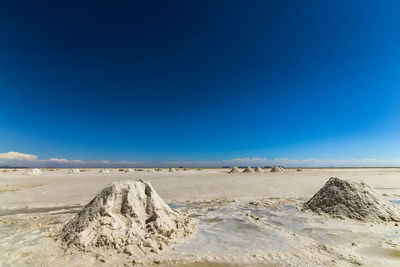 Scenic view of desert against clear blue sky