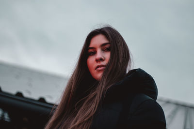 Portrait of beautiful young woman against black background