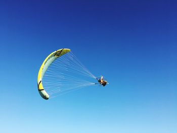 Low angle view of kite against clear blue sky