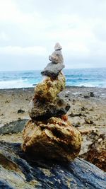 Close-up of rock on beach against sky