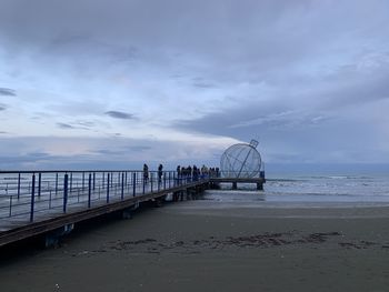View of pier on sea against cloudy sky
