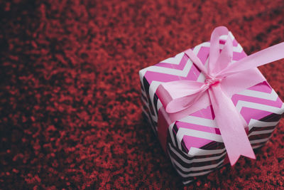 High angle view of pink gift box on rug