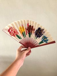 Close-up of hand holding multi colored umbrella