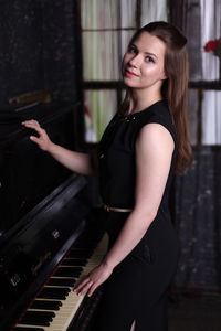 Smiling young woman playing piano