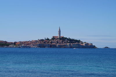 Buildings against clear blue sky with waterfront