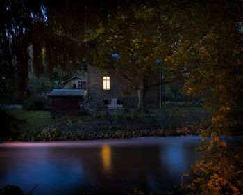 Reflection of trees in lake at night