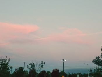 Low angle view of street lights against sky during sunset