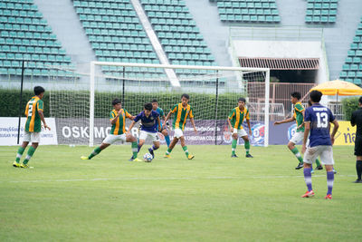 Group of people playing soccer on field