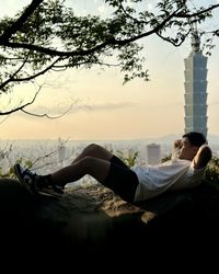 Low section of a man laying on the rock during the sunset 