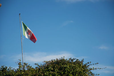 Low angle view of flag against blue sky