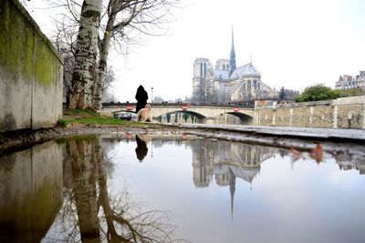 Reflection of arch bridge and building on river