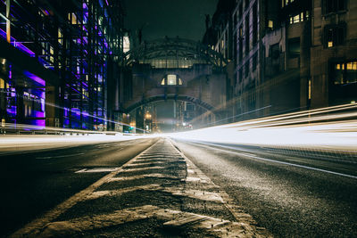 Light trails on road along buildings at night