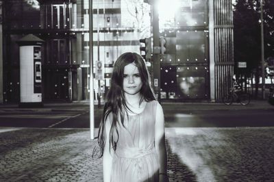 Young woman standing on street at night