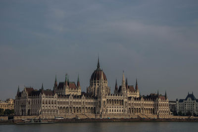 View of buildings in city against cloudy sky