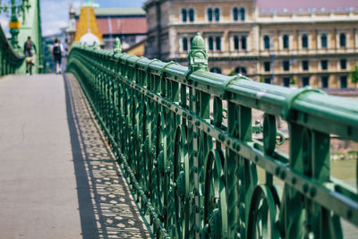 Metal railing by bridge in city