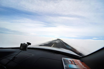 Airplane flying over snowcapped mountains against sky