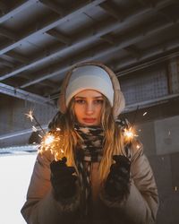 Portrait of young woman standing against wall