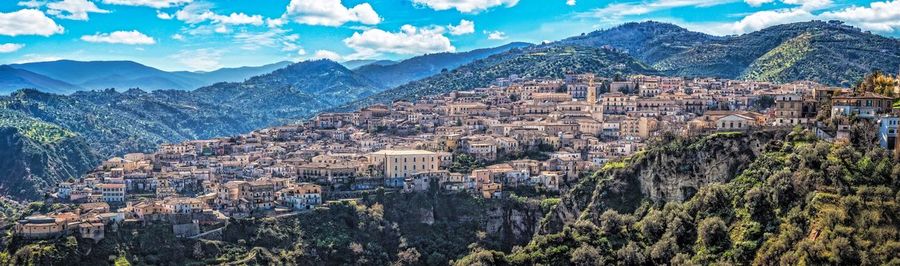 Panoramic view of townscape and mountains against sky