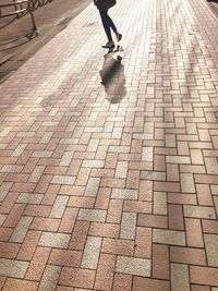 Low section of man walking on cobblestone