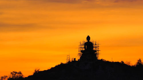 Building buddha on mountain at sunset