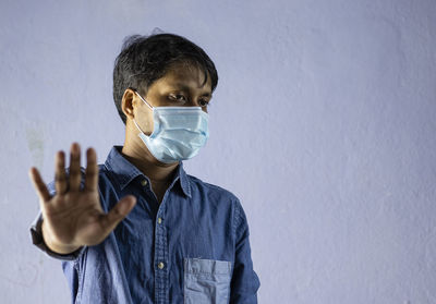 Portrait of man standing against wall